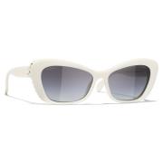Elegante ovale solbriller med hvit acetatramme